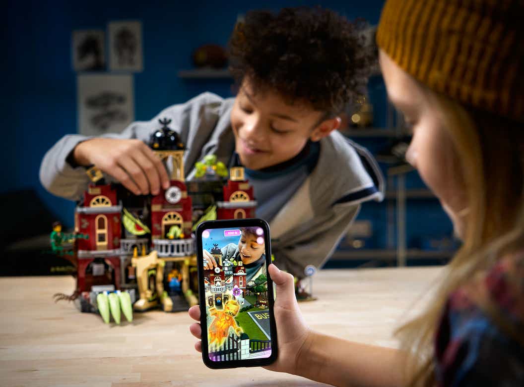 image of boy and girl playing with a LEGO Hidden side set using augmented reality