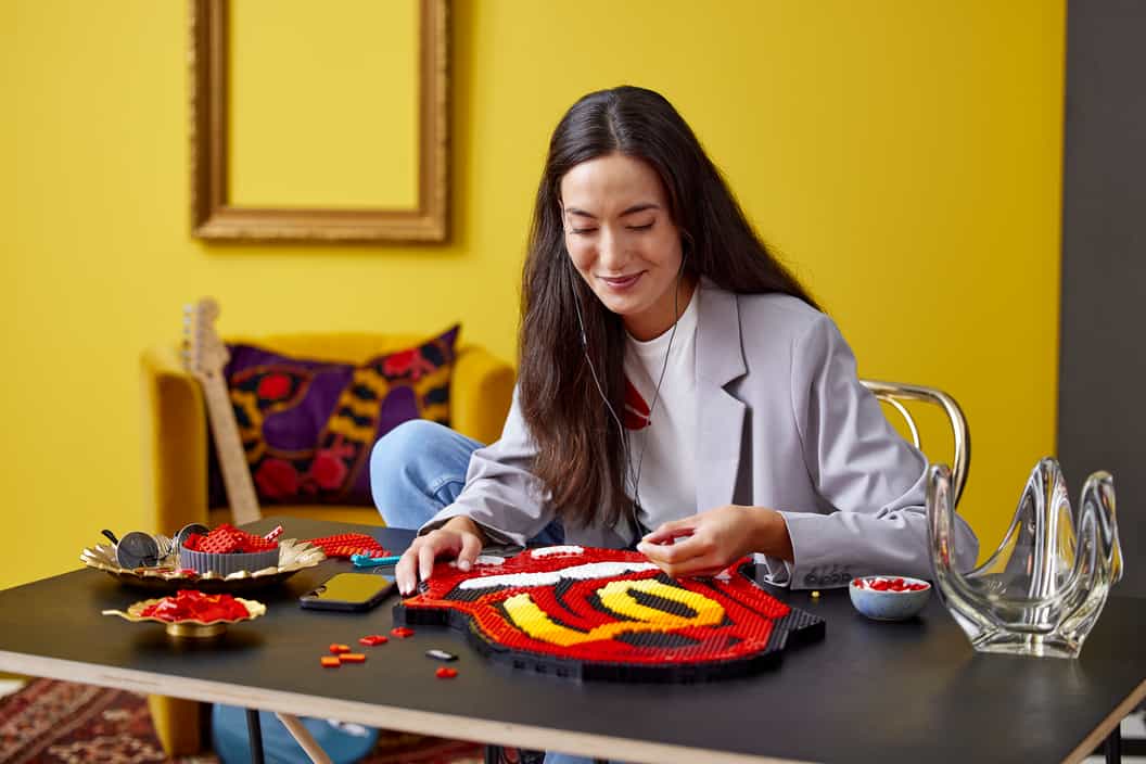 Frauen, die das Lego Art Rolling Stones-Set bauen, während sie Musik hören