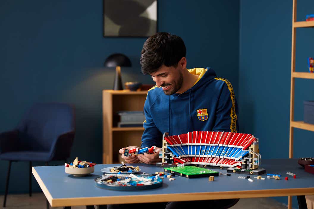 Image de style de vie d'un homme construisant l'ensemble LEGO Camp Nou