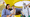 LEGO colleagues standing round a laptop smiling