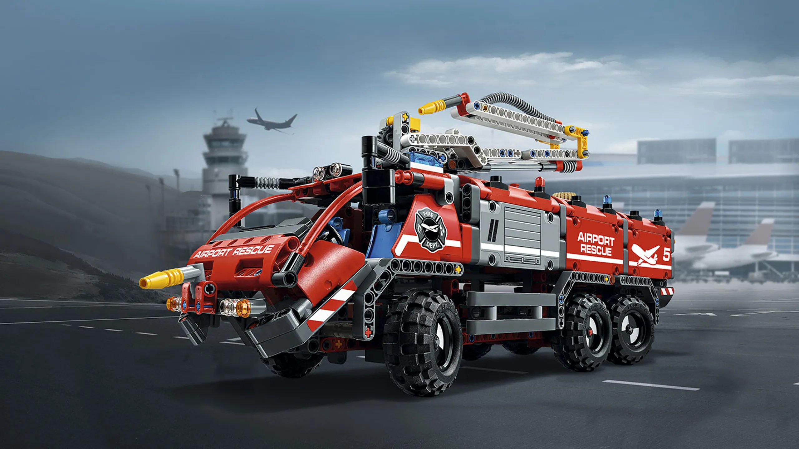 LEGO Technic - 42068 Airport Rescue Vehicle - the vehicle features a classic red color scheme, large driver’s cab, wing mirrors, opening tool storage compartment, four-cylinder engine with moving pistons, twin-axle steering, double rear axle and chunky tires.