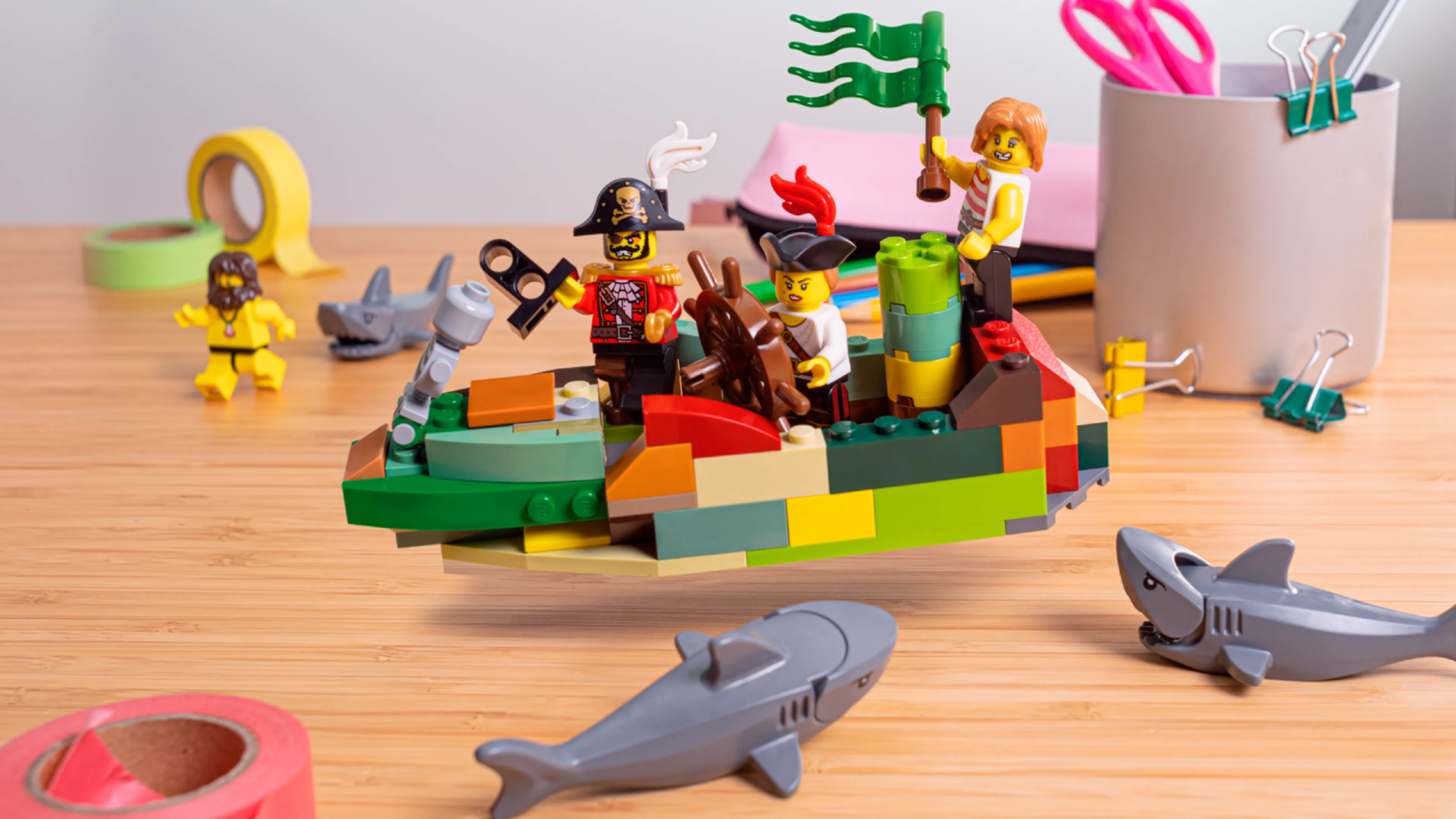 Minifiguren, umgeben von Haien, bauen das Schiff fertig 