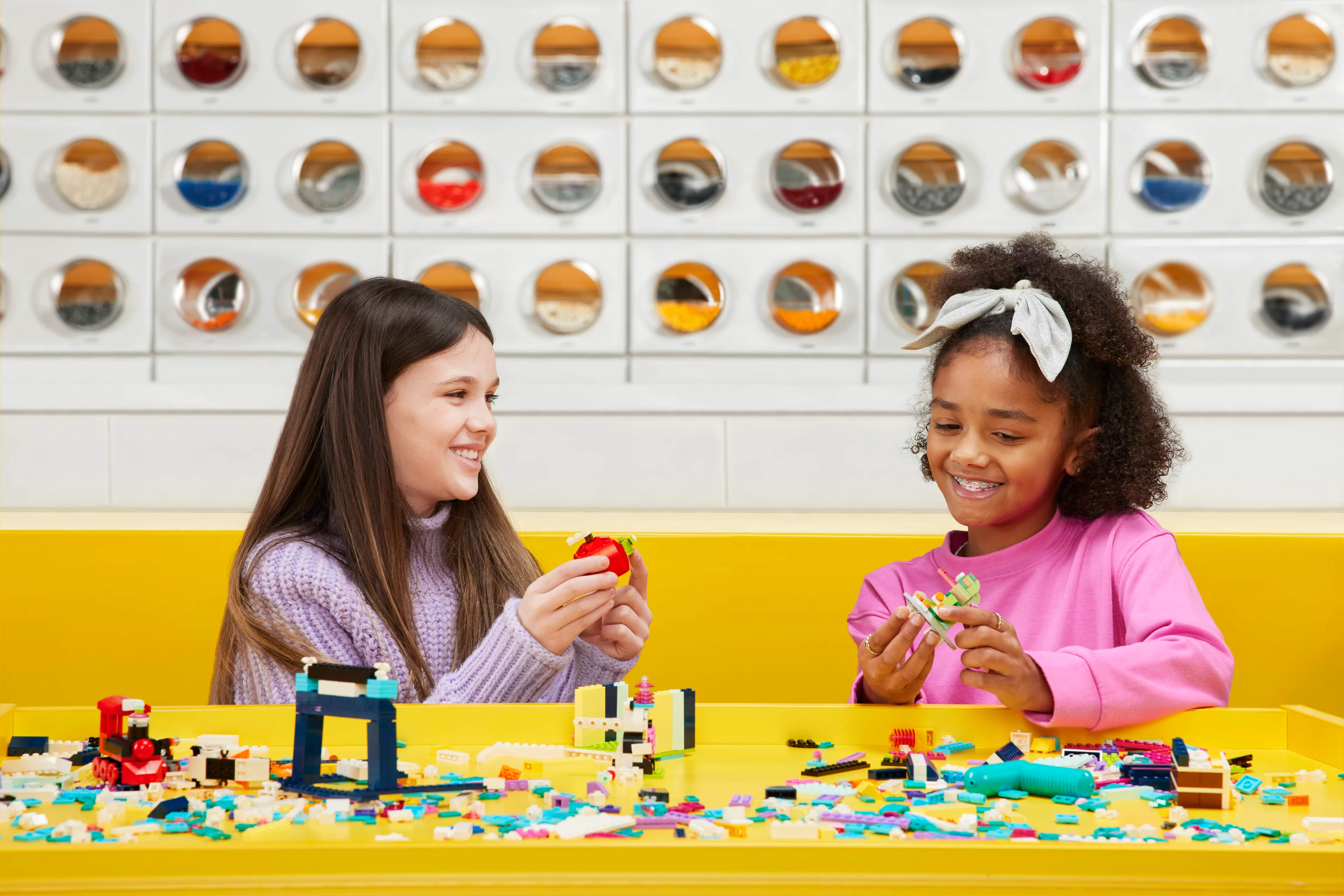 Two girls playing with bricks at a table