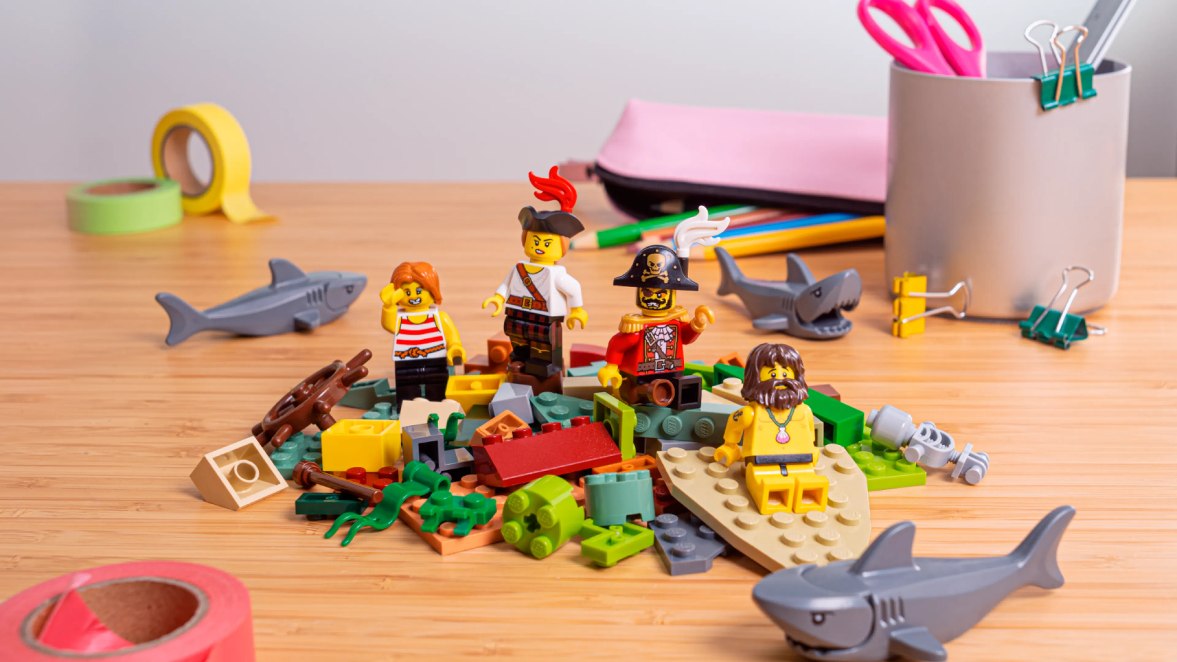 Minifigurki siedzące na stosie klocków LEGO