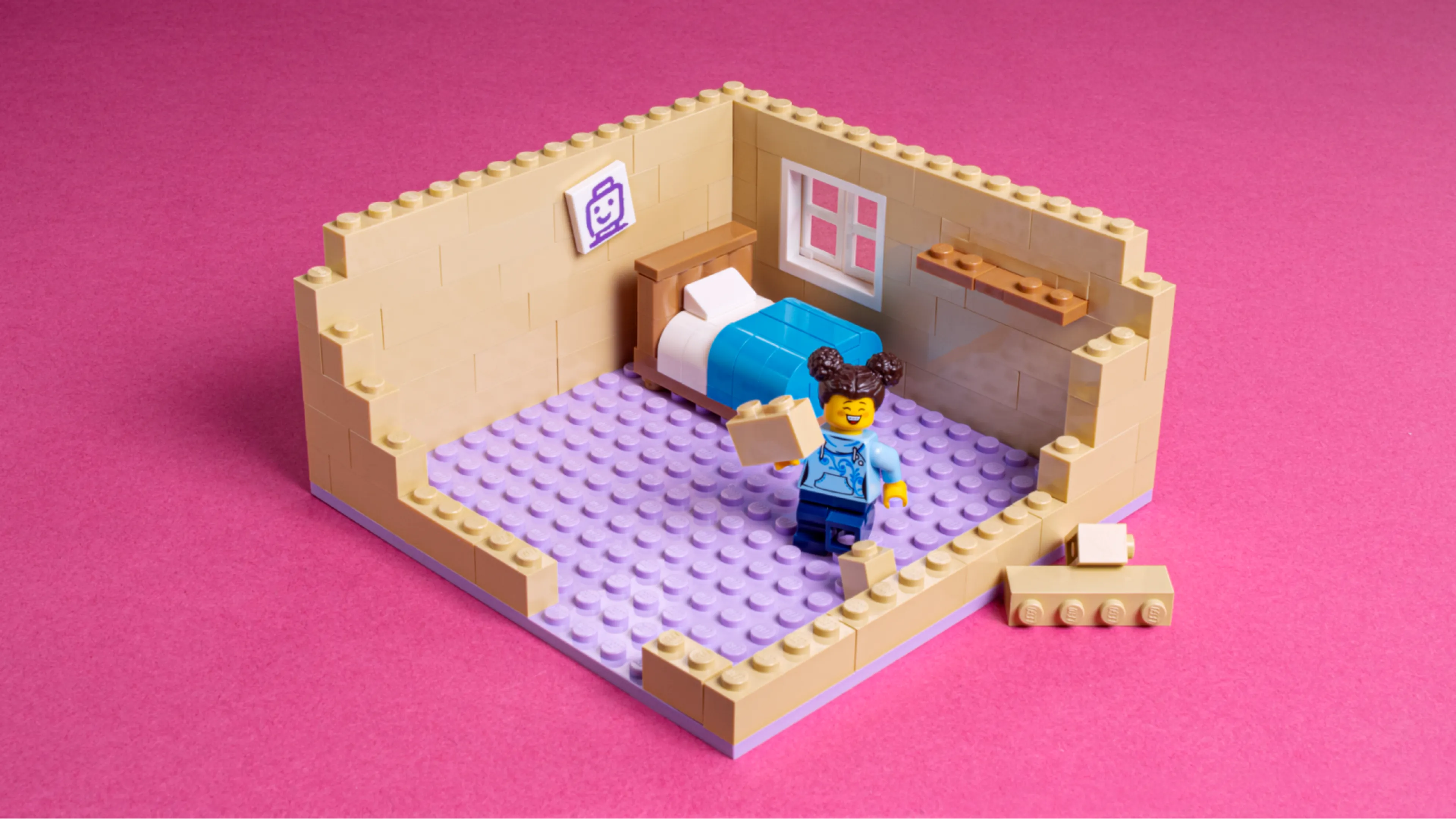 A minifigure standing next to a LEGO bed in an unfinished LEGO bedroom