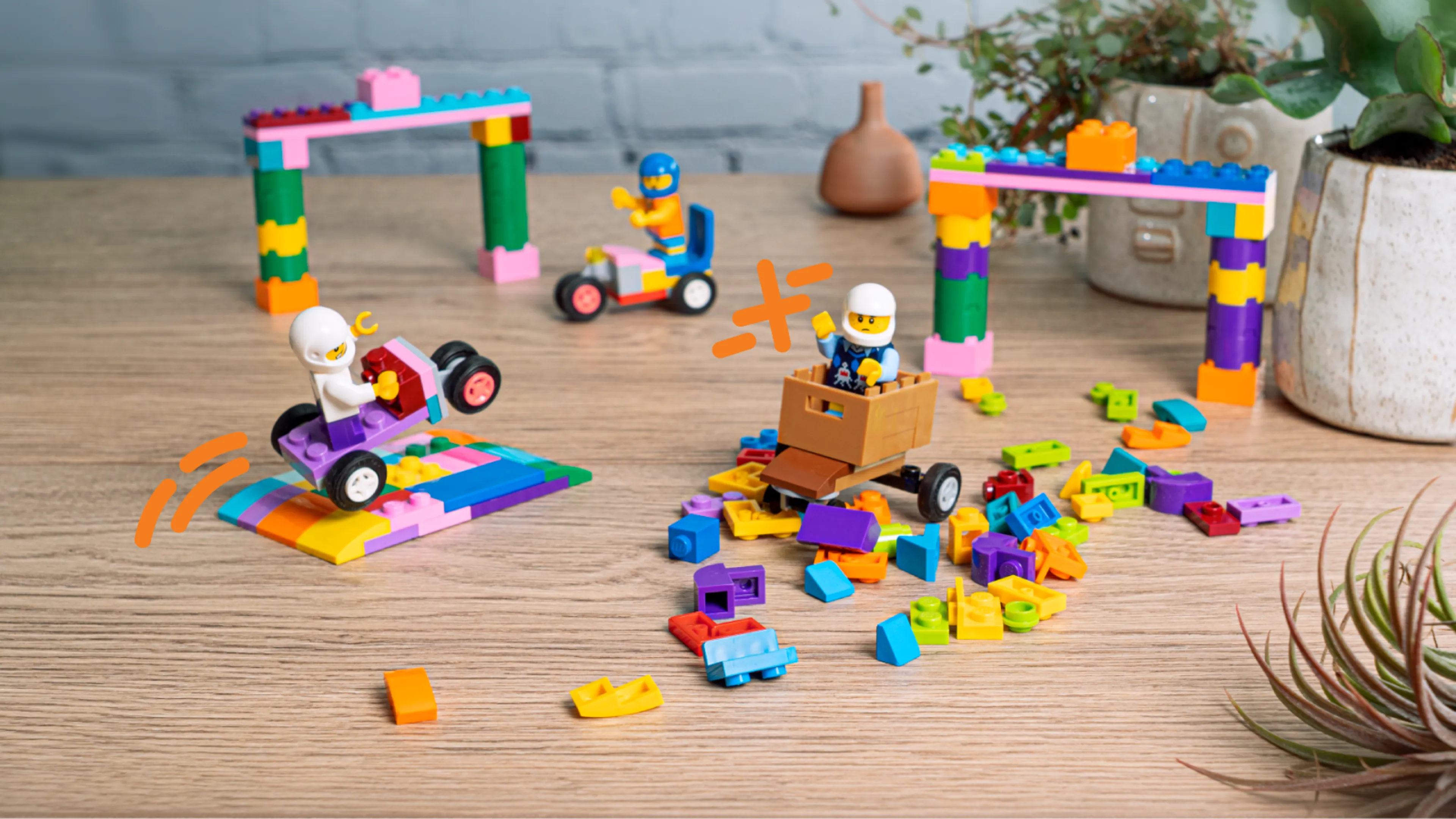Minifiguren, LEGO zeepkistauto's, hekken en een stapel stenen