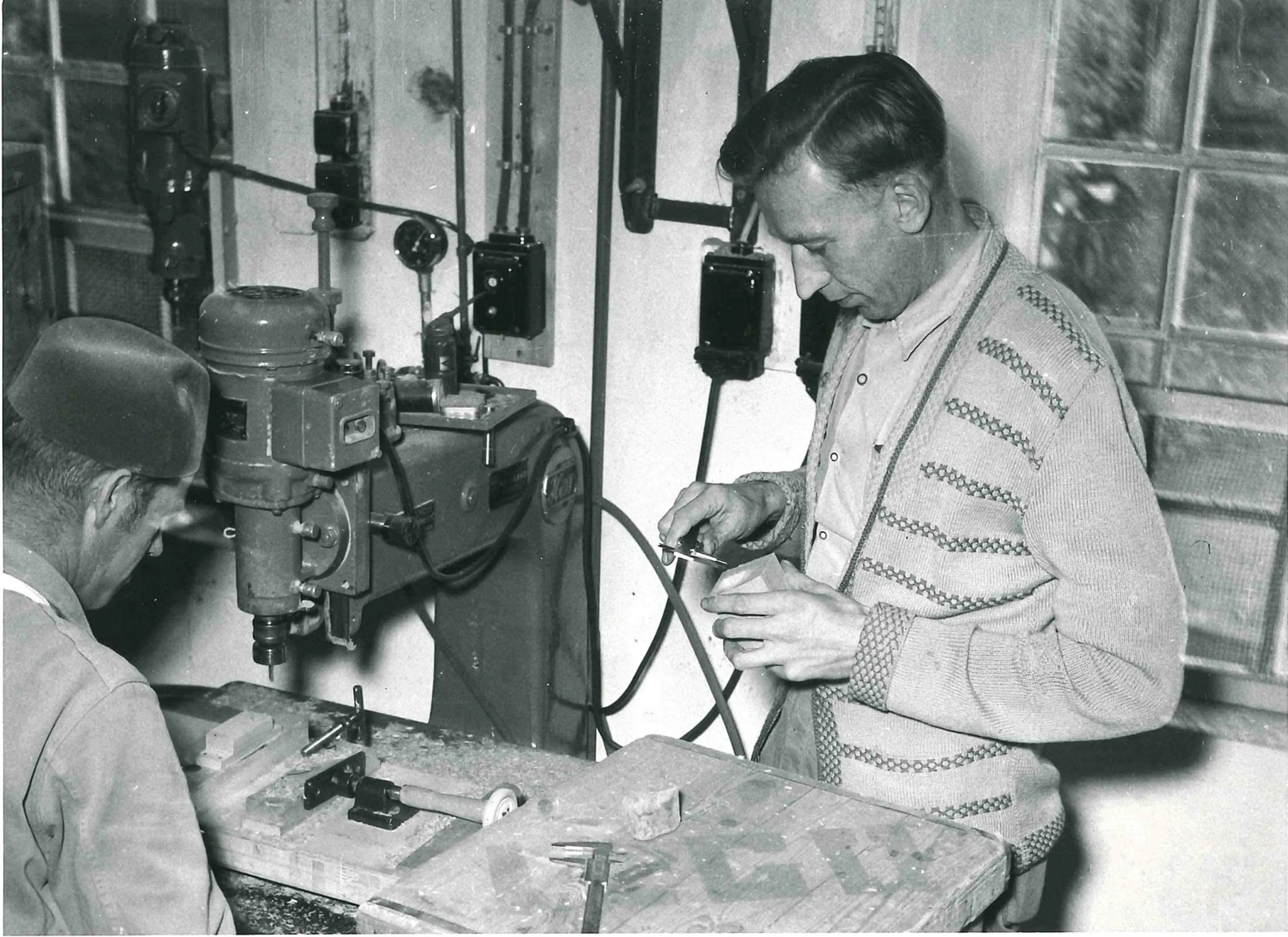 Two employees by a milling machine