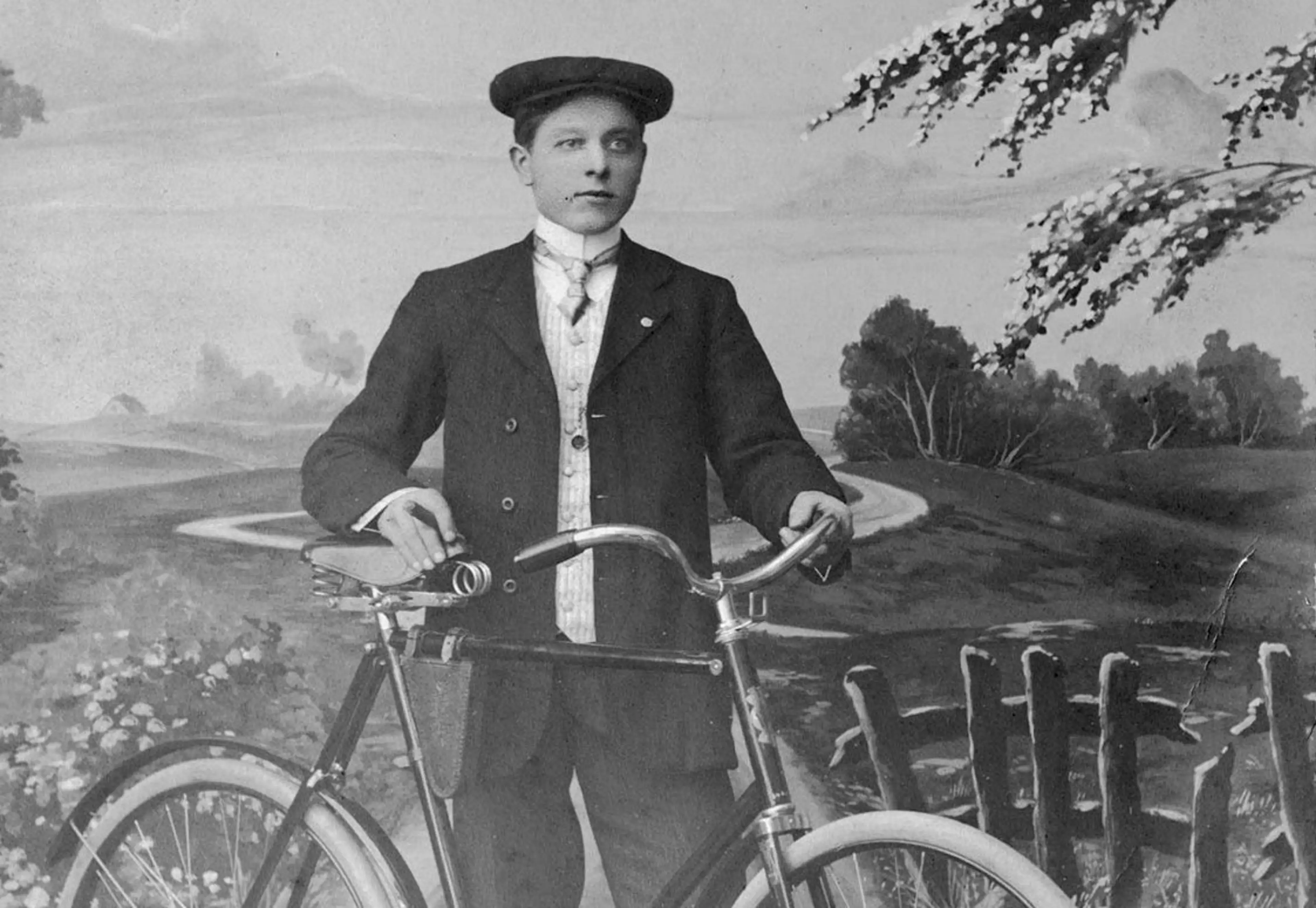 A young Ole Kirk standing by a bicycle