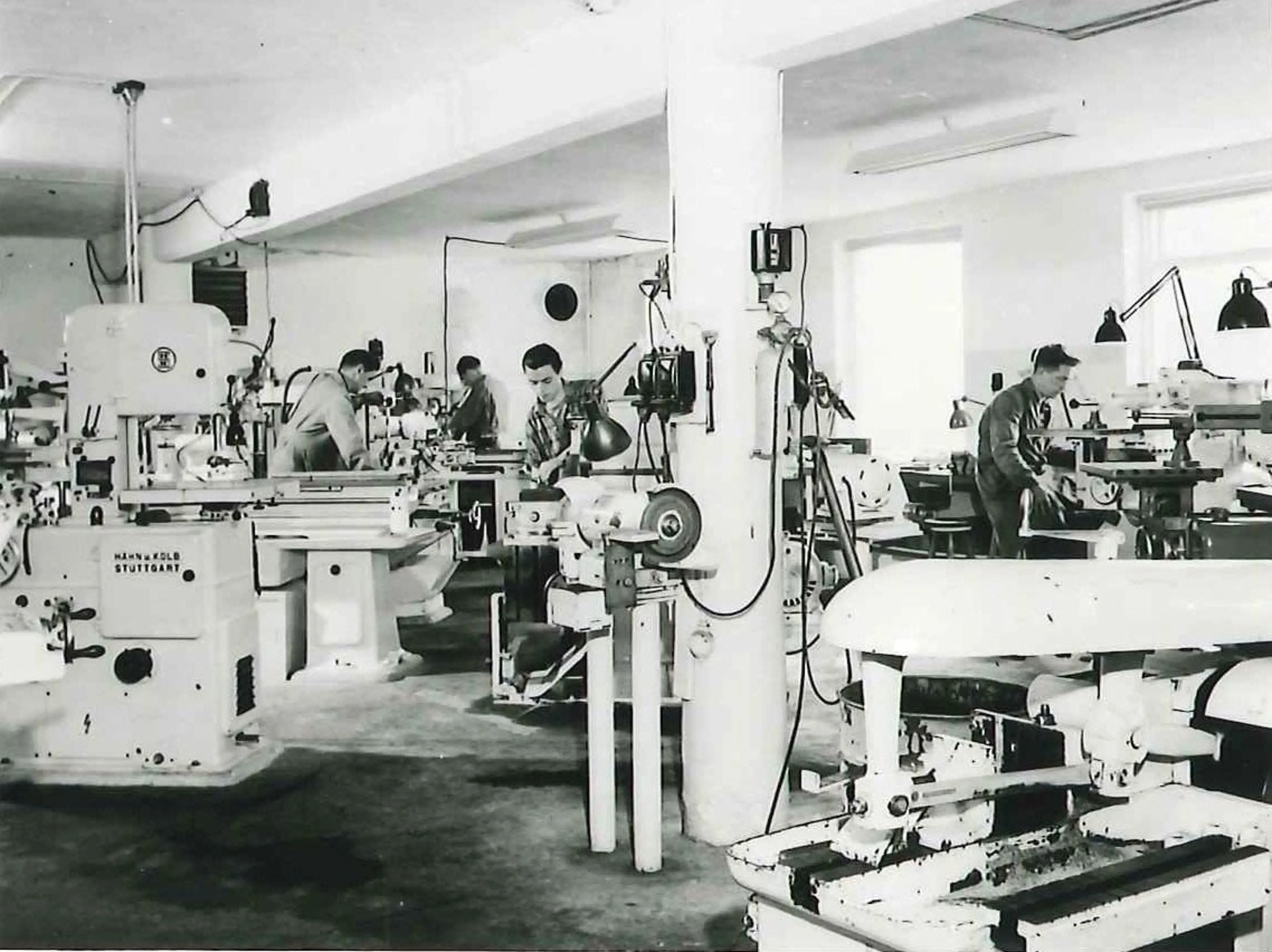 people operating machines inside the mold workshop