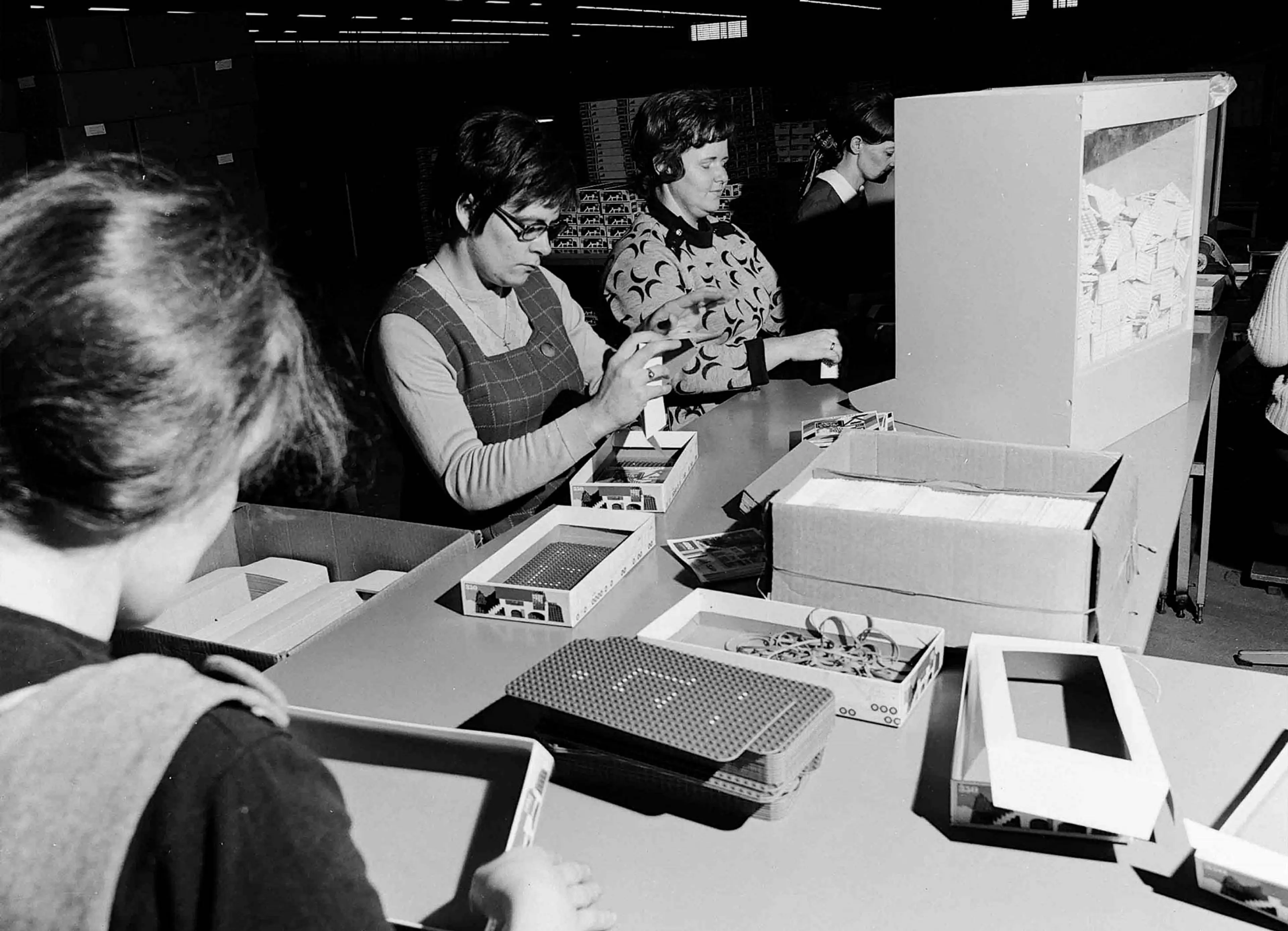 employees manually packing LEGO sets