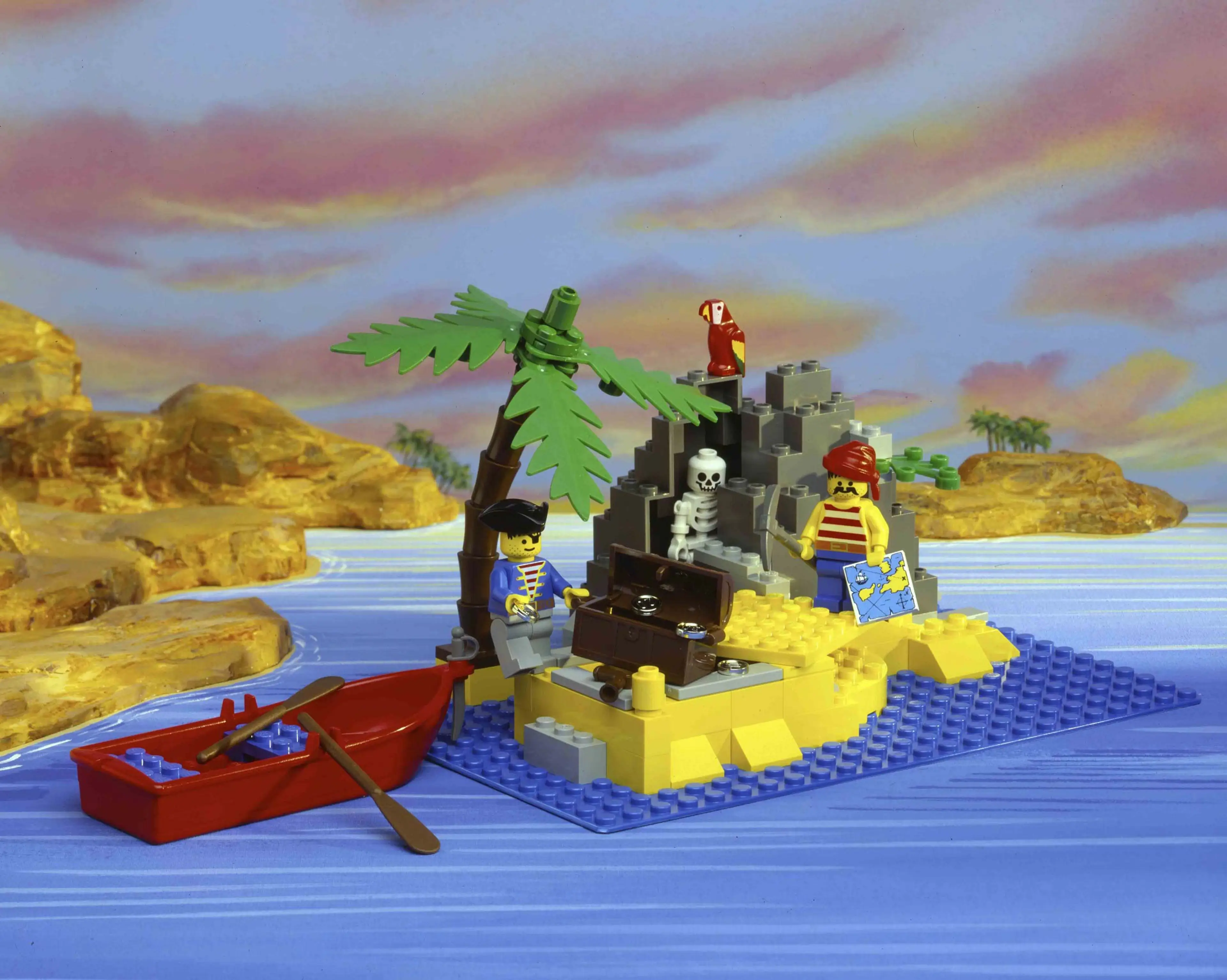 Small LEGO Pirates set comprising of two minifigures, a skeleton, a parrot, a boat and a small deserted island