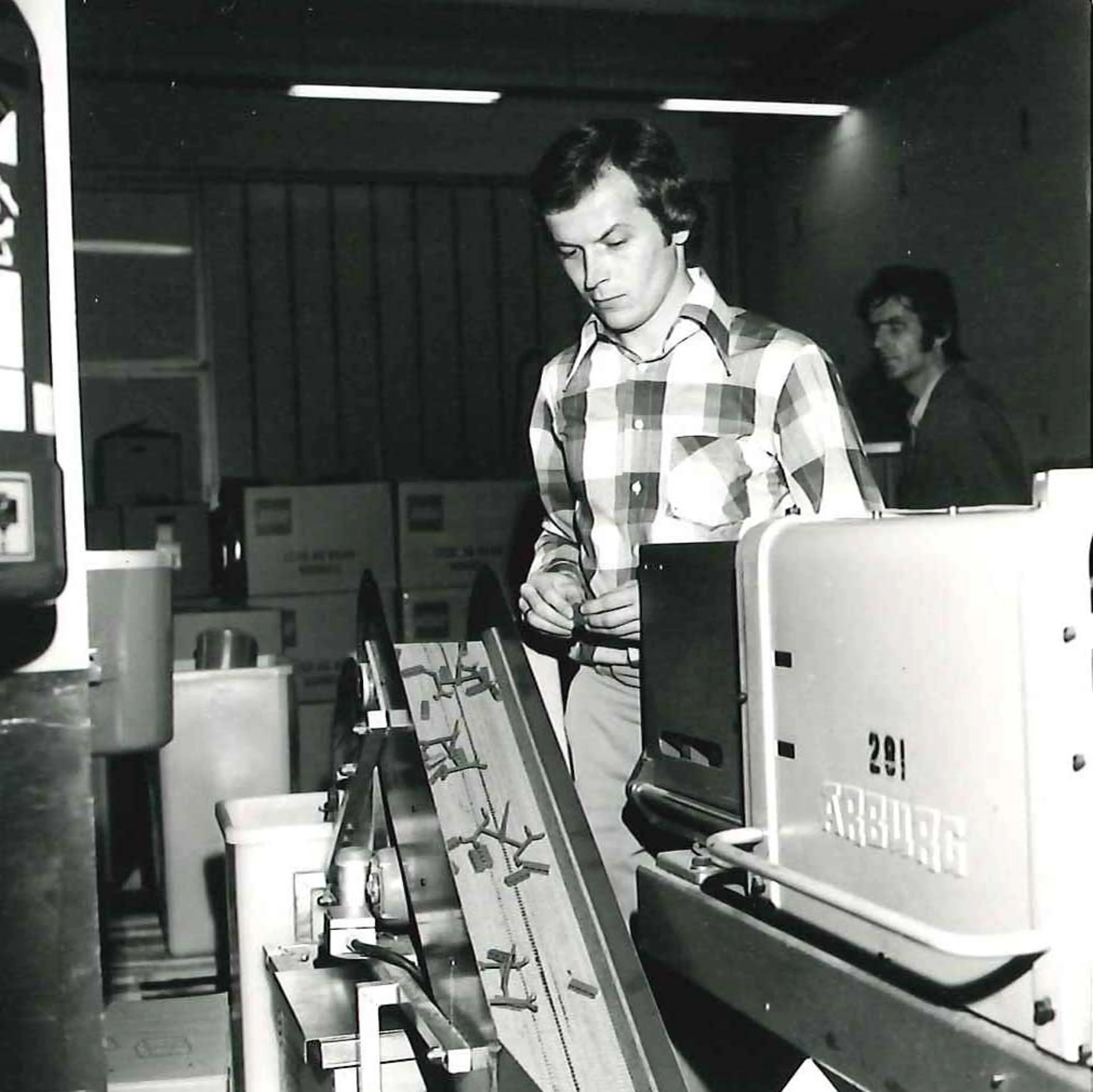 Third generation LEGO owner Kjeld Kirk Kristiansen next to a machine in a factory