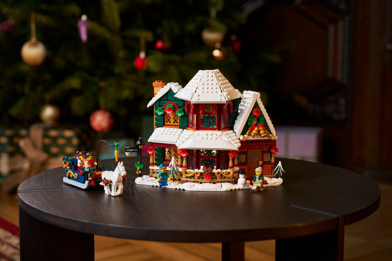 LEGO Icons 11387 Holiday House lit up in a snowy winter village scene