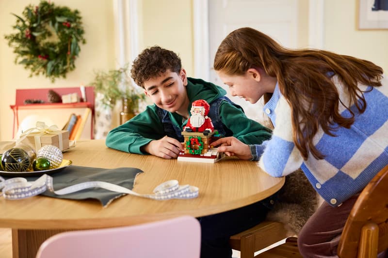 Two people building LEGO Santa's Holiday Countdown at a table