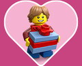 Heart-shaped background with a LEGO minifigure holding up a brick-built present.
