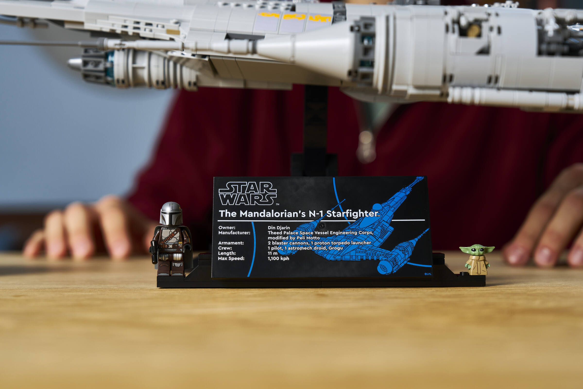 Close-up of information plaque of LEGO&reg; Star Wars&trade; The Mandalorian's N-1 Starfighter&trade; with 2 minifigures attached.