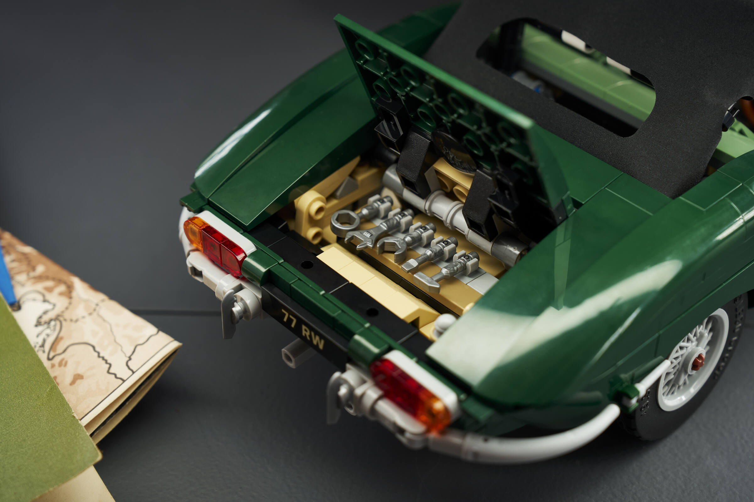 Close-up of the open trunk of a LEGO® Icons Jaguar E-Type set revealing the 5-piece tool kit inside.