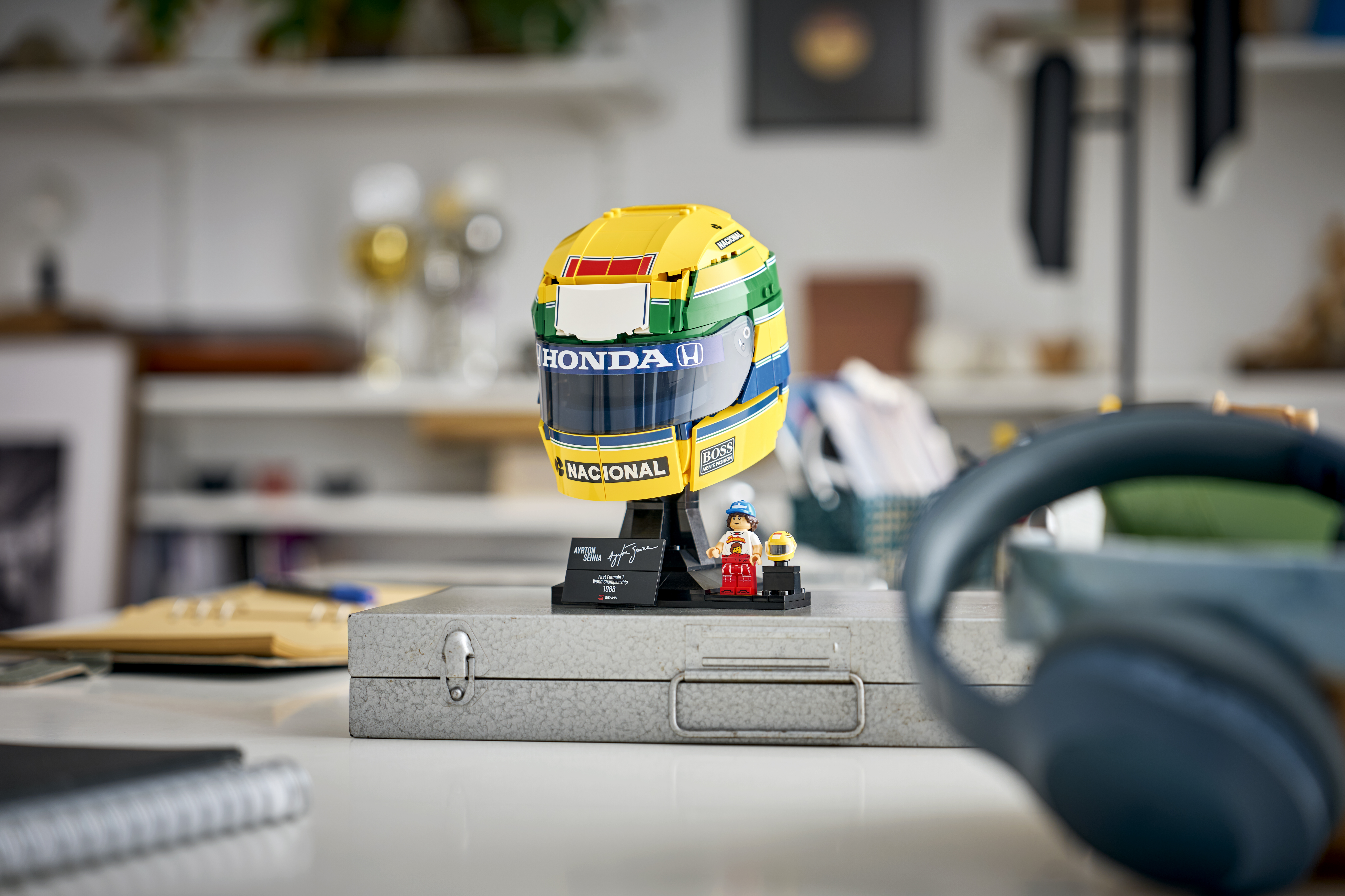 LEGO Editions 43024 Ayrton Senna Helmet displayed in a lifestyle environment shot with yellow and green details