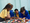 Children standing around a table filled with LEGO bricks
